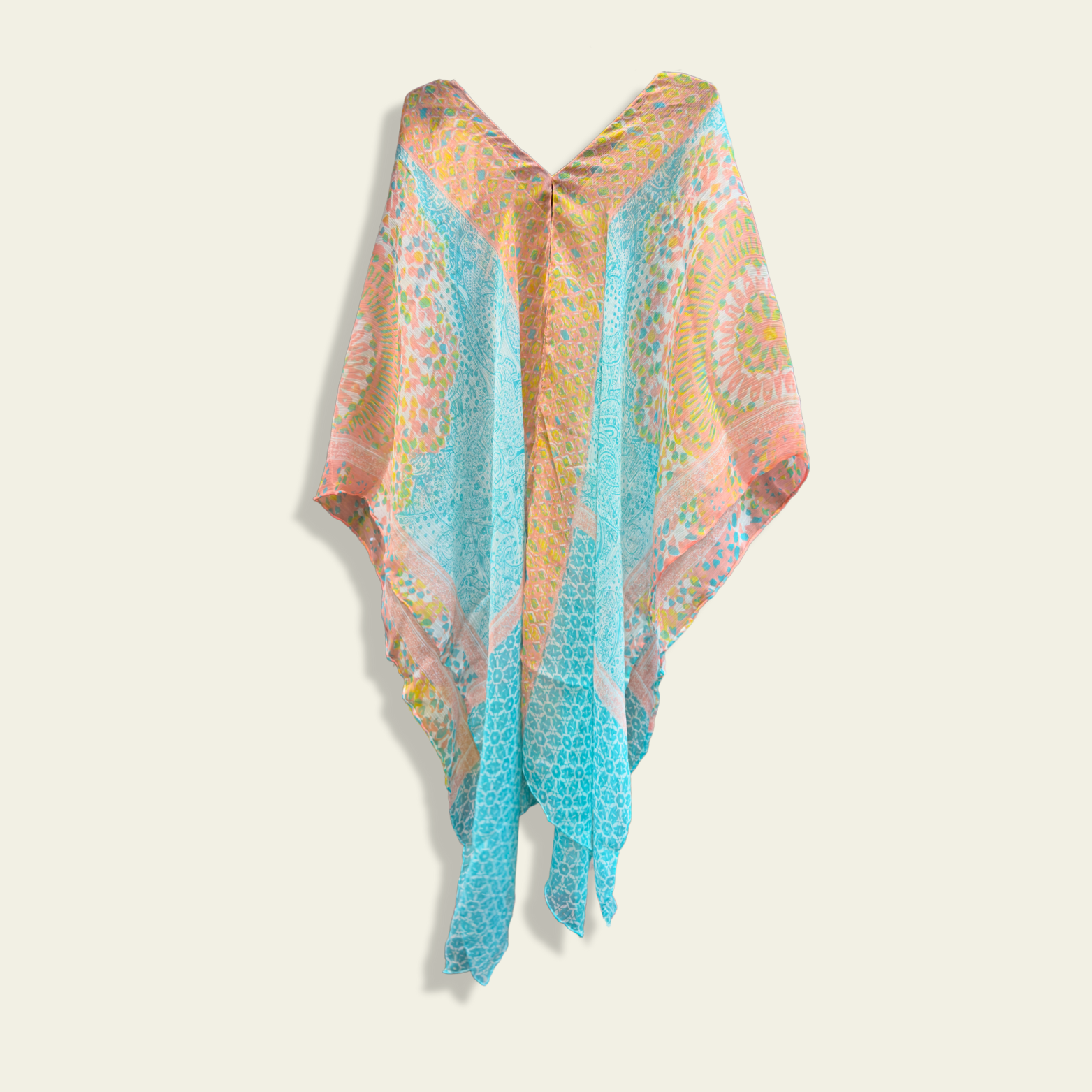 This lightweight chiffon poncho drapes beautifully, showcasing a vibrant blend of blue and coral with an abstract print.